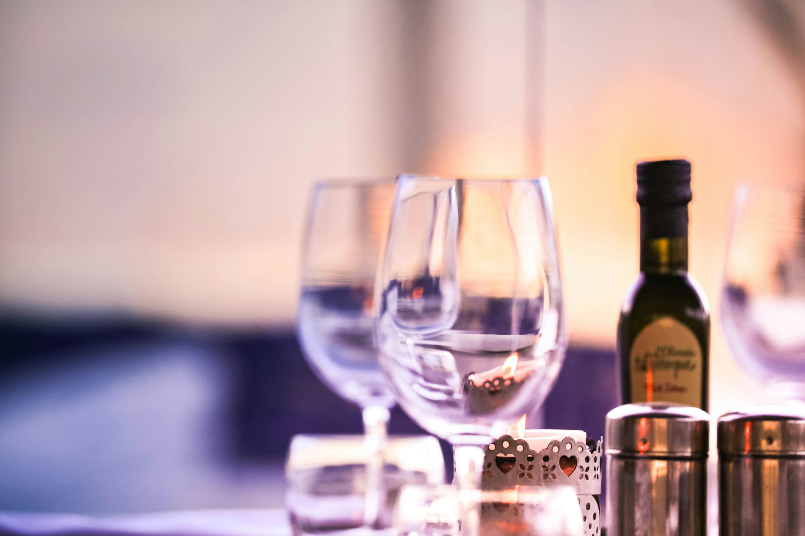 Close-up of a sophisticated dining setup featuring wine glasses and a bottle indoors.