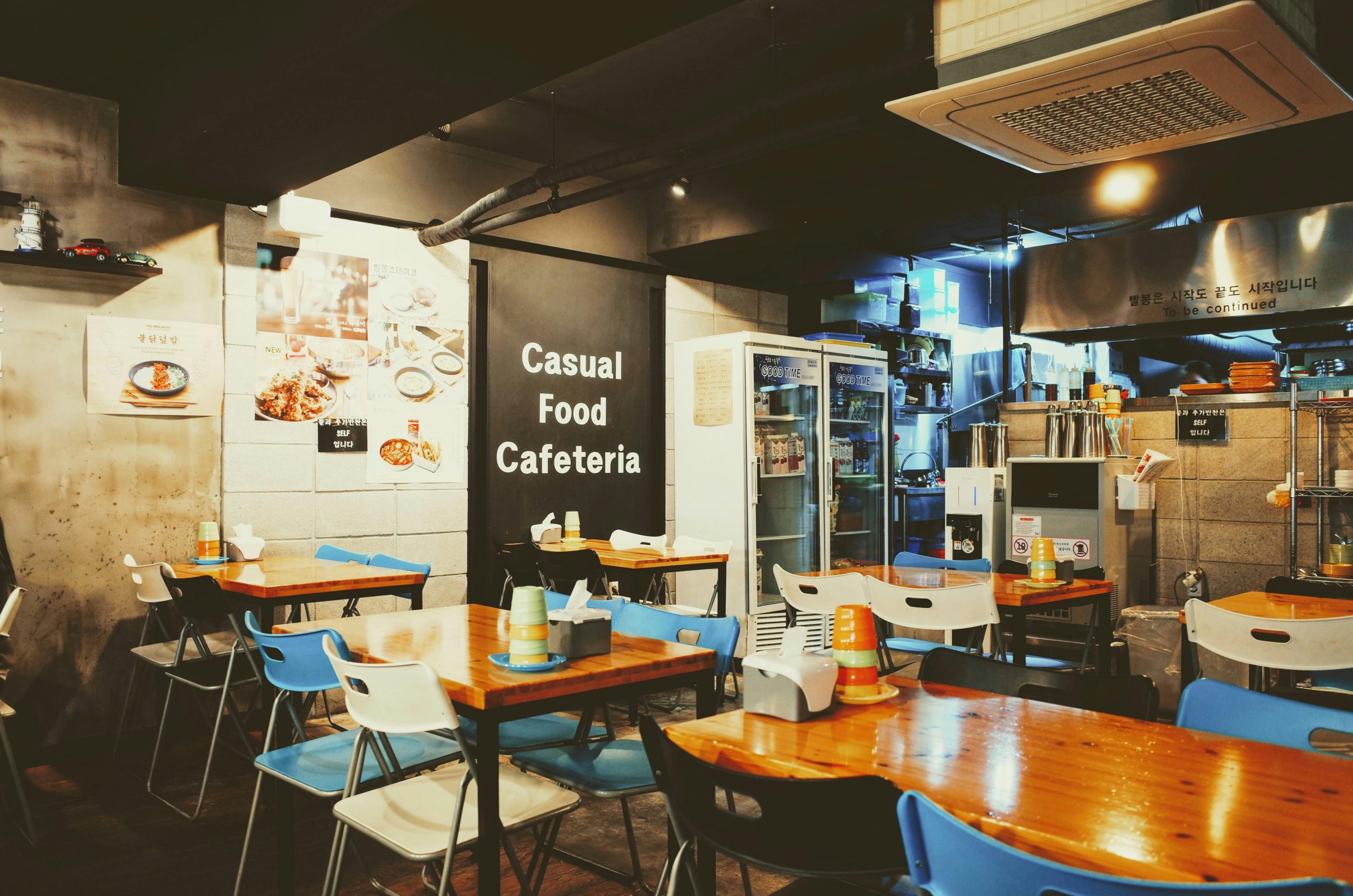 A cozy casual cafeteria interior with tables and chairs, located in Busan, South Korea.