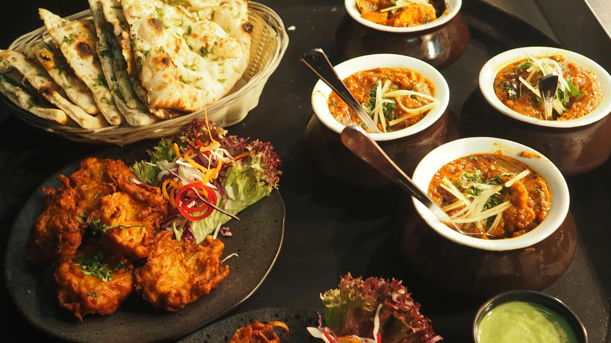 A mouth-watering display of Indian cuisine featuring naan, curry, and pakoras perfect for a delightful meal.